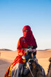 © Cavan Images - woman enjoying a camel ride in the Sahara