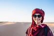 © Cavan Images - portrait of woman wearing a turban in the Sahara desert