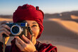 © Cavan Images - female photographer with rangefinder camera in the Sahara