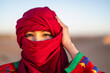 © Cavan Images - portrait of woman wearing a turban in the Sahara desert