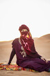 © Cavan Images - portrait of woman wearing a turban in the Sahara desert