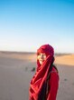 © Cavan Images - portrait of woman wearing a turban in the Sahara desert