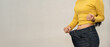 © Thitiporn - Woman showing weight loss result by holding loose jeans waistband, slim waist after diet and healthy lifestyle, fitness success, body transformation concept. weight loss, diet, slim, waist, success.
