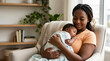 © OlgaNeuroArt - African American mother holding sleeping newborn baby on chest. Happy black mom bonding with infant in armchair. Parenthood and love concept