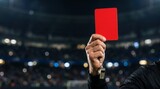 Close up of soccer referee holding red card penalty during football match in stadium night lights