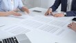 © volha_r - Business partners discussing contract terms, reviewing legal documents during an office meeting, focusing on agreement details and professional negotiation strategies