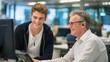 © PirisaTK - Two men collaborate happily at a computer in a modern office setting, engaged in a friendly and productive work session.