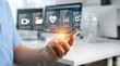 © Me Faqih - Doctor Using Smartphone for Digital Healthcare Services with Telemedicine and Electronic Health Records Icons Overlay