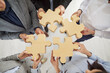 © Studio Romantic - Team jigsaw puzzle matching, business teamwork with game pieces showing cooperation unity and partnership, hands close up join pieces in office, business people together for team business idea search