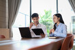 © jojo - Young Professionals Discuss Business Strategy During Meeting With Laptop And Clipboard In Modern Office