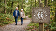 © FrameLab - Happy Senior Couple Walking on Nature Trail Behind a Wooden Healthy Lifestyle Sign Illustrating Wellness and Active Retirement