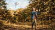 © one - A young boy joyfully flying a kite in a sun-dappled autumn forest, enjoying outdoor leisure activities