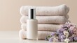 © Firadoaw - Elegant cosmetic bottle surrounded by soft towels and pastel floral arrangement, clean skincare editorial aesthetic