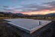 © Rodeo - concrete slab foundation for a new house at sunset with mountain view