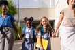 © luisrojasstock - Diverse schoolgirls holding hands with mothers walking to school