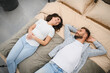 © Serhii - Young couple lying bed choosing furniture for new home