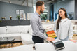 © Serhii - Furniture store consultant showing fabric samples to customer