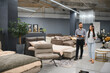© Serhii - Sales consultant assisting client in furniture store showroom