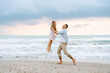 © maxbelchenko - A smiling father is having fun with his daughter on the seashore. A young man and a little girl are playing together and enjoying the seascape. Concepts of nature, childhood, and love.