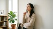 © kila - A young woman in casual clothing is thoughtfully looking away while holding a pen to her chin, appearing to be in a state of deep contemplation or decision-making