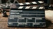 © Eve - Vintage wooden movie clapperboard on rustic desk with film reels and camera lens. Old cinema production equipment slate for director, cameraman, scene and take markers. Hollywood concept.