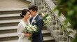 © PhotoArtHub - Couple embracing with wedding bouquets, symbolizing love and union on a grand stone staircase, representing a new beginning.