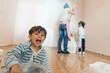 © Antonio Recena - Mother and her children painting home room. Funny boy dirty looking at camera