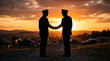 © drims - Silhouette of two military officers shaking hands at sunset