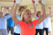 © Connect Images - Female instructor lifting free weights in a senior's fitness class