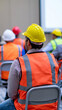 © Curioso.Photography - Construction workers attending a safety briefing wearing helmets and high visibility vests at a job site.Construction workers attending a safety briefing wearing helmets and high visibility vests.