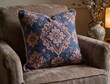 © Beniamin - Embroidered decorative pillow resting on upholstered armchair indoors