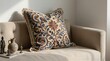 © Beniamin - Decorative embroidered cushion resting on neutral sofa in living room