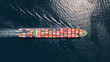 © Nasos Zovoilis - Container vessel carrying numerous shipping containers across the open sea, symbolizing global trade, international logistics, and maritime transportation, seen from a high aerial perspective