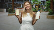 © Krakenimages.com - Woman holds white chocolate bar and milk bottle with eyes closed and smiling in building atrium; contentment indulgence.