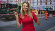 © Krakenimages.com - Blonde woman pointing finger and making ok sign with hands on a street near roadworks; playful approval.