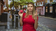 © Krakenimages.com - Blonde woman holding pomegranate in hand on a cobbled street with a wry facial expression; skepticism temptation.