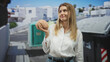 © Krakenimages.com - Blonde woman holds a model brain in one hand on a sunlit street beside dumpsters and white buildings; amusement urban commentary.