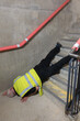 © RCH Photographic - Mature construction worker trips and falls while working on concrete stairs in a new build.  Senior engineer slips and falls down a flight of stairs while surveying a building.