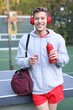 © New Africa - Young man with sports bag, headphones and bottle of water at outdoor gym