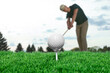 © New Africa - Golf ball and player on course, selective focus