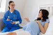 © Home-stock - Smiling pregnant woman talking with doctor during prenatal checkup