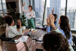 © Jovo Jovanovic/Stocksy - Business meeting with hands raised in agreement.