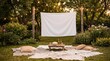 © Irina - Outdoor cinema setup with a blank screen and seating on grass in rustic style in warm natural colors representing a cozy backyard movie night with copy space