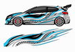 © audia - Silver hatchback with blue checkered racing wave graphics.