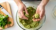© Yuliya - Female hands shaping green chickpea mixture into falafel balls over a glass bowl on a white table, with copy space. This photo is ideal for vegetarian recipe blogs and cooking websites.