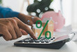 © JOURNEY STUDIO7 - Real estate loan interest rate, hands using calculator with wooden houses and upward percentage house, Mortgage planning, home loan calculation, secure property finance and banking investment