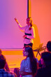 © Lustre Art Group  - Female presenter pointing at blank screen during neon business seminar. Concept of corporate workshop, presentation coaching, team education, conference speaking and communication training.