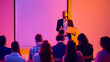 © Lustre Art Group  - Businessman holding laptop while presenting to audience near blank screen. Concept of seminar training, corporate workshop, business communication, leadership and professional education.