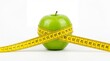 © Abdul - Fresh green apple wrapped with a yellow measuring tape for diet and health on white background