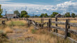 © gleb - Abandoned rural homestead with dry grass and weathered wooden fences under cloudy sky creating nostalgic countryside atmosphere and isolation mood